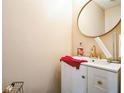 Stylish powder room with a round mirror, elegant vanity, and modern gold faucet at 3302 Waldrop Trl, Decatur, GA 30034