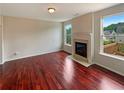 Bright living room featuring hardwood floors, a fireplace, and large windows with views of the outdoors at 3695 Santa Rosa Way, Douglasville, GA 30135