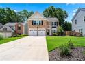Inviting brick home with a lush front lawn, two-car garage, and manicured landscaping at 615 Rosedown Way, Alpharetta, GA 30022