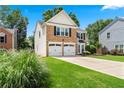 Attractive brick and siding home with a two-car garage, showcasing a green lawn at 615 Rosedown Way, Alpharetta, GA 30022