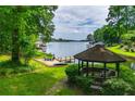 Scenic backyard featuring a gazebo, sandy lounging area, and serene lake views at 9018 Lakeview Pkwy, Villa Rica, GA 30180