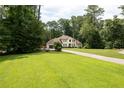 A glimpse of the beautiful home with an attached garage with a vast green lawn and mature trees at 1908 Musket Ct, Stone Mountain, GA 30087