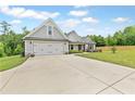 Single-Gathering home boasting a long concrete driveway leading to an attached two-car garage at 2241 N 16 Hwy, Whitesburg, GA 30185