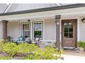 Welcoming front porch with rocking chairs, decorative plants, and a charming wooden front door at 2241 N 16 Hwy, Whitesburg, GA 30185