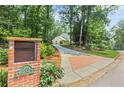 View of the brick mailbox and driveway leading to the house with mature trees and landscaping at 260 Waverly Hall Dr, Roswell, GA 30075