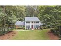 Stately two-story home with a manicured lawn, classic columns, and mature landscaping at 260 Waverly Hall Dr, Roswell, GA 30075