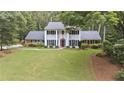 Stately two-story home with a manicured lawn, classic columns, and mature landscaping at 260 Waverly Hall Dr, Roswell, GA 30075