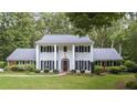 Traditional two-story home with white columns, black shutters, manicured lawn, and mature landscaping at 260 Waverly Hall Dr, Roswell, GA 30075