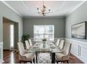 Elegant dining room featuring modern table setting, wainscoting, chandelier and hardwood floors at 5018 Upper Elm St, Atlanta, GA 30349