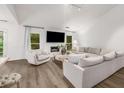 Spacious living room with cozy fireplace and abundant natural light from the windows at 5315 Bentley Hall Dr, Alpharetta, GA 30005