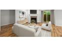 Bright living room featuring a fireplace, hardwood floors, and sliding doors to the outside at 1384 N Crossing Ne Dr, Atlanta, GA 30329