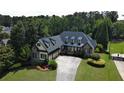 Aerial view of a stately home featuring a manicured lawn, mature trees, and long driveway at 154 Gold Leaf Trail Trl, Powder Springs, GA 30127