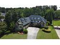 Spacious home with dormer windows, mature landscaping, and a long, curved driveway at 154 Gold Leaf Trail Trl, Powder Springs, GA 30127