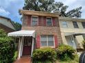 Charming two-story brick home with red shutters, showcasing its curb appeal and inviting entrance at 964 Glynn Oaks Dr, Clarkston, GA 30021