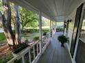 Inviting covered front porch with fresh paint, complemented by plants and a view of the surrounding greenery at 3054 Whisper Knob Rd, Marietta, GA 30062