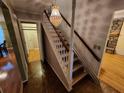 View of staircase featuring carpeted steps, classic chandelier, and hardwood floors in the entryway at 3054 Whisper Knob Rd, Marietta, GA 30062