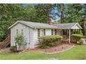 View of the side and back of the house with a small deck, landscaping, and backyard at 307 Little Hickory Ln, Woodstock, GA 30189