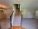 Open entryway featuring staircase with wood and white trim and neutral walls and carpet throughout at 180 Preston Oaks Dr, Johns Creek, GA 30022