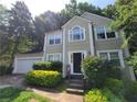 View of a two-story home with traditional architectural design, manicured landscaping, and a two-car garage at 180 Preston Oaks Dr, Johns Creek, GA 30022