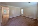 Neutral-toned living room featuring a large window, neutral carpet, and views into another room at 180 Preston Oaks Dr, Johns Creek, GA 30022