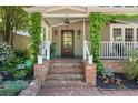 Inviting front porch entry with brick steps, decorative lighting, and lush landscaping at 22 The Prado Ne, Atlanta, GA 30309