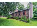 Lovely home exterior with brick and landscaping, red shutters, and chimney at 1744 Cum Laude Way, Lawrenceville, GA 30044
