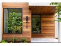 Home's front entrance featuring wood paneling, modern windows, and manicured landscaping at 16 Bonnie Ln, Atlanta, GA 30328