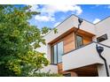 Corner view of a home featuring neutral exterior, wood accents, modern gutters, and mature landscaping at 16 Bonnie Ln, Atlanta, GA 30328