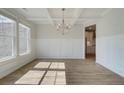 Elegant dining room boasts natural light, wood floors, coffered ceiling, and decorative wainscoting at 421 Hartsfield Rd, Mcdonough, GA 30253