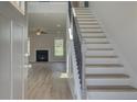 Bright entryway featuring a staircase, wood floors, and a view of the living room with a fireplace at 421 Hartsfield Rd, Mcdonough, GA 30253
