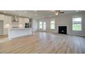 Open-concept living space with fireplace, wood floors, lots of natural light, and adjacent kitchen at 421 Hartsfield Rd, Mcdonough, GA 30253