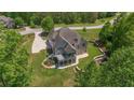 Beautiful rear exterior featuring a screened porch, patio, landscaped yard, and a private, wooded backdrop at 893 Somersby Dr, Dallas, GA 30157