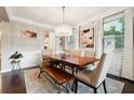 Elegant dining room with a large wood table, stylish chairs, and a modern chandelier creating a sophisticated space at 4710 Robins Nest Ln, Cumming, GA 30041