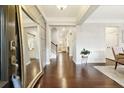 Welcoming entryway with gleaming hardwood floors, paneled walls, and an elegant full-length mirror at 4710 Robins Nest Ln, Cumming, GA 30041