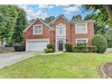Two-story brick home featuring a manicured lawn and established landscaping enhancing its curb appeal at 5015 Riverthur Pl, Peachtree Corners, GA 30096