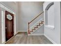 Bright foyer featuring hardwood floors, stairs with white spindles and wood railing, and a decorative front door at 5015 Riverthur Pl, Peachtree Corners, GA 30096