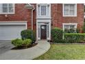 Close-up of a home's front entrance with decorative door, manicured landscaping, and brick facade at 5015 Riverthur Pl, Peachtree Corners, GA 30096