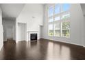 Bright living room with fireplace, hardwood flooring, and large windows at 5575 Mirror Lake Dr, Cumming, GA 30028