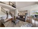 Spacious living room with an open staircase, hardwood floors, and a view of the modern kitchen at 5915 Read Rd, Suwanee, GA 30024