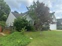 A quaint home with grey siding, a two-car garage, and a cozy, tree-lined yard at 1241 Key Manor Ln, Lawrenceville, GA 30045