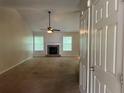 Spacious living room featuring a stone fireplace, ceiling fan, and ample natural light at 1241 Key Manor Ln, Lawrenceville, GA 30045