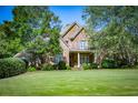 Traditional two-story brick home with a lush green lawn and mature trees in a serene setting at 197 Westbrook Rd, Carrollton, GA 30116