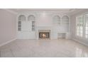 Elegant living room featuring a fireplace, built-in shelving, and plantation shutters at 5003 Village Terrace Dr, Dunwoody, GA 30338