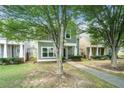 Eye-level view of the charming home with green siding and mature trees in a residential neighborhood at 126 Wellbrook Ne Ct, Conyers, GA 30012