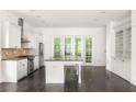 Bright kitchen with a granite island and stainless steel appliances at 9071 Selborne Ln, Chattahoochee Hills, GA 30268