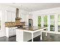 Bright kitchen with an island, granite countertops, and stainless steel appliances at 9071 Selborne Ln, Chattahoochee Hills, GA 30268
