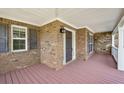 Covered front porch with brick exterior and pink wood flooring at 167 Gothards Creek Dr, Powder Springs, GA 30127