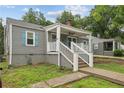 Charming home with gray siding, blue shutters, and inviting front porch with white railing at 3006 Dogwood Dr, Hapeville, GA 30354