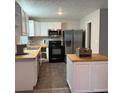 Well-lit kitchen featuring stainless steel appliances, tile flooring, butcher block countertops, and island at 3990 N Quail Dr, Douglasville, GA 30135