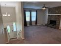 Inviting living room with a stone fireplace, neutral paint, large windows, and new ceiling fan at 3990 N Quail Dr, Douglasville, GA 30135